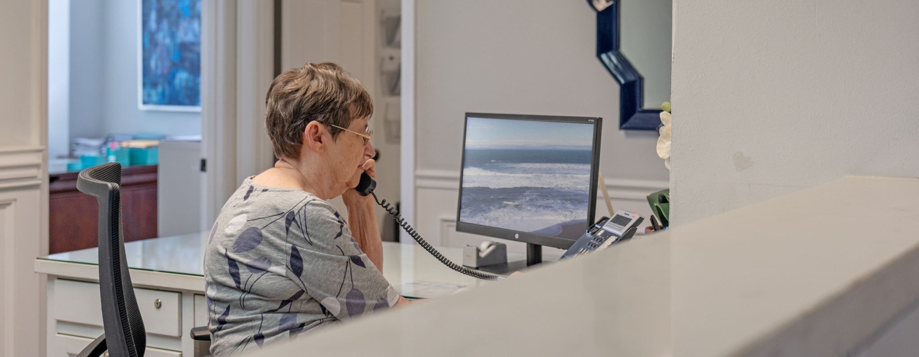 a woman sitting a desk talking on the phone